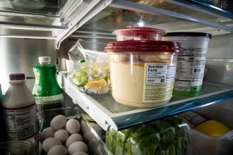 Відкритий холодильник із продуктами на полицях