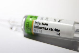 Шприц і флакон вакцини проти грипу